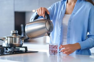 Woman Pouring Water from Kettle