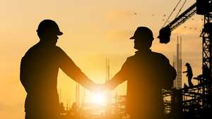 Construction workers shaking hands